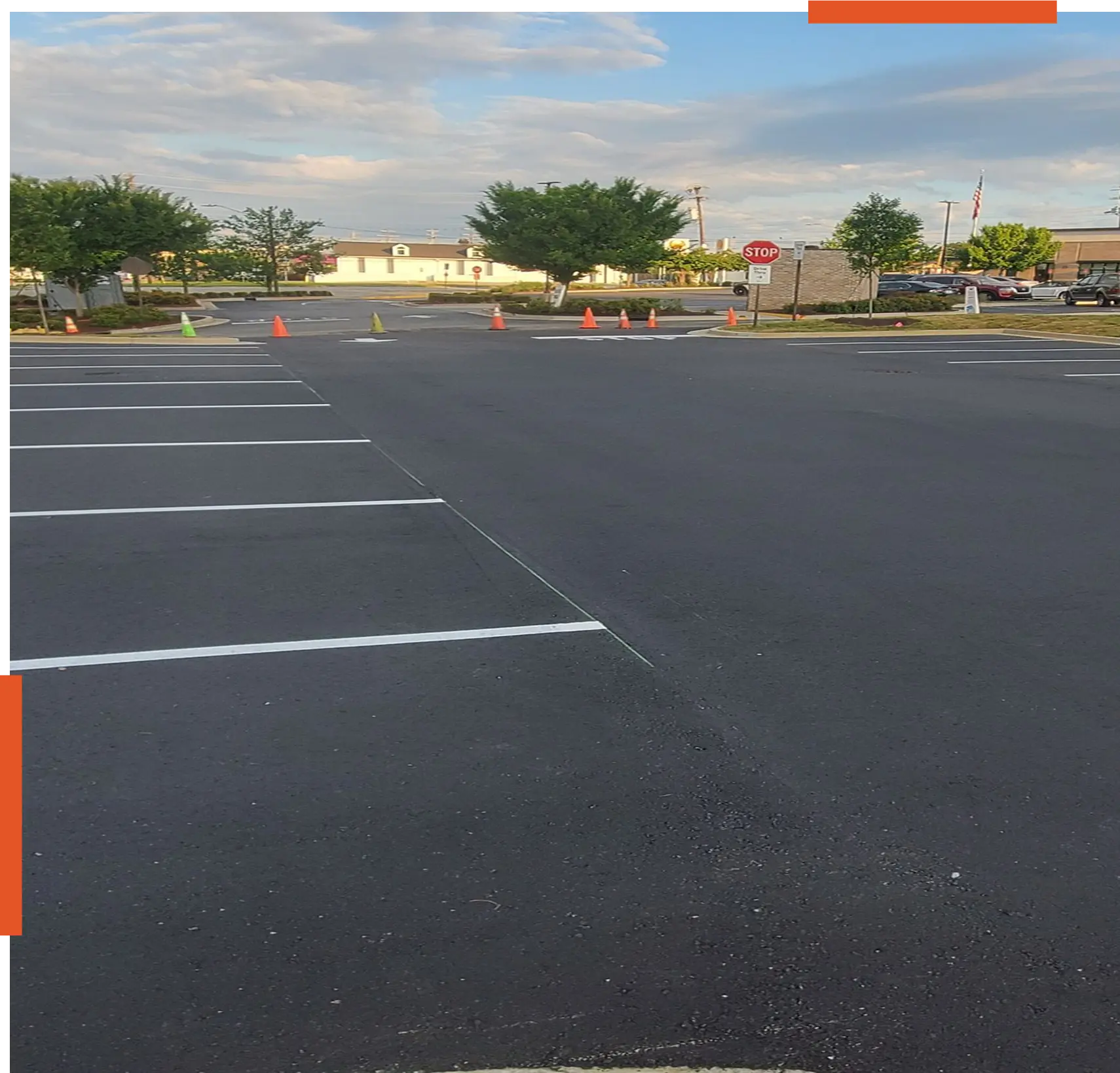 img (3) Empty parking lot with traffic cones, trees.